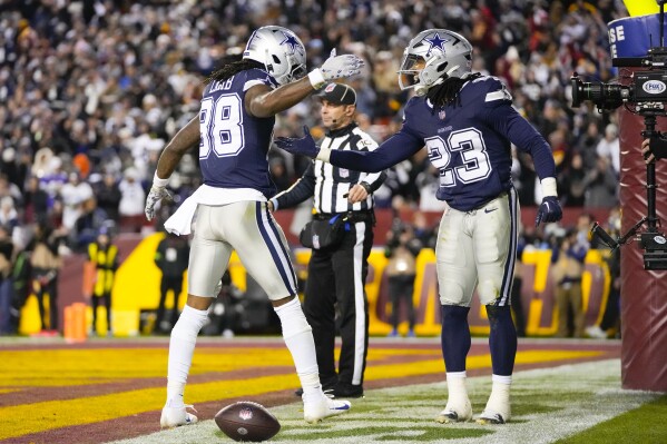 Dallas Cowboys wide receiver CeeDee Lamb (88) celebrates his touchdown with teammate running back Rico Dowdle (23) during the second half of an NFL football game against the Washington Commanders, Sunday, Jan. 7, 2024, in Landover, Md. (AP Photo/Mark Schiefelbein)
