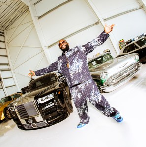 In his hangar with, from left, a 1978 Pontiac Trans Am, a 2018 Rolls-Royce Phantom, a 1957 Chevrolet Belair, and a 1967 Chevrolet Camaro. Louis Vuitton jacket, $3,300, and pants, $2,270, both in denim, and Ross’s own Vuitton sneakers.